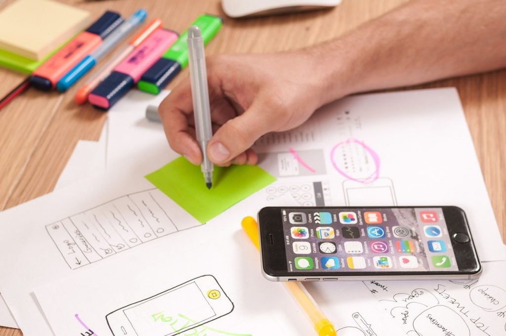 A hand with notepads and a phone 