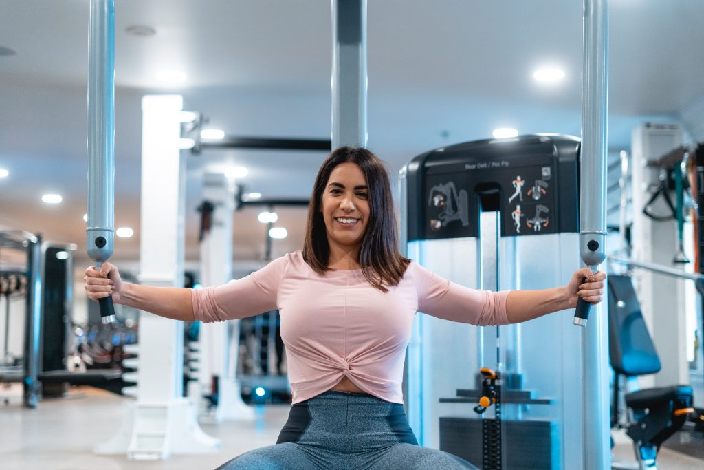 Woman on chest fly machine